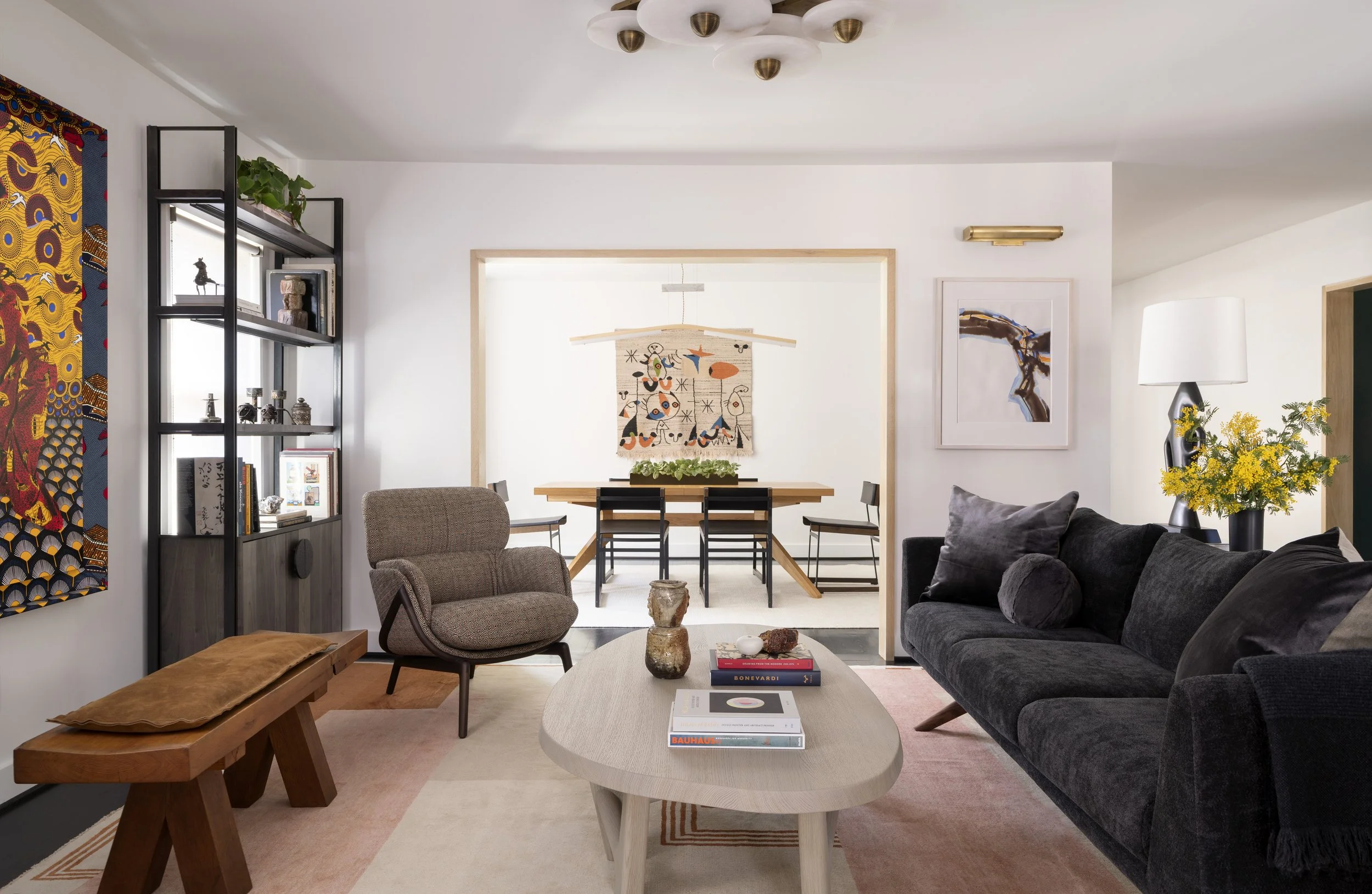 Living room at Boulevard Oaks, a Houston Museum District renovation by Cravotta Interiors: charcoal sofa, oval stone coffee table, and a view to the dining room.